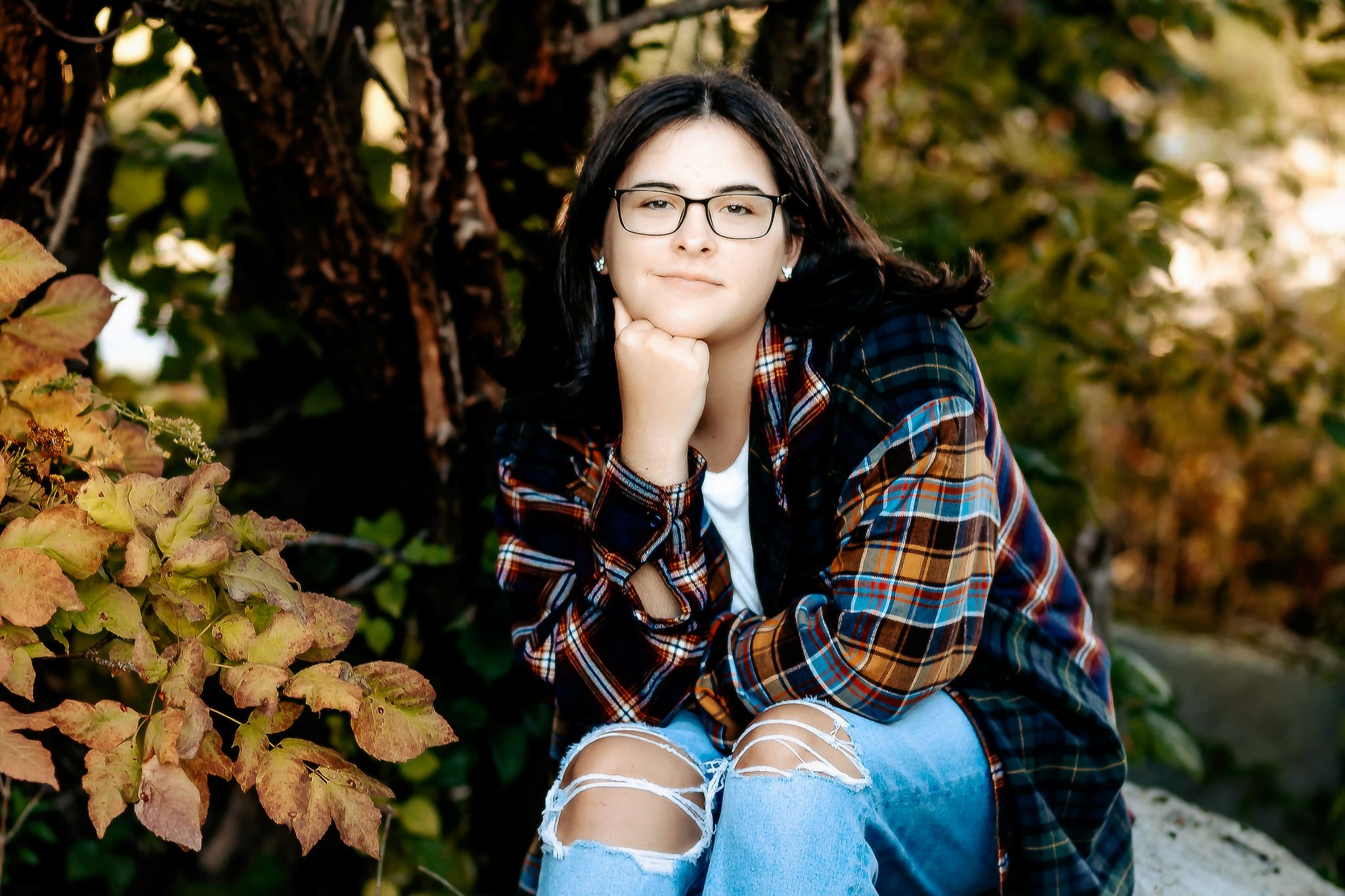 High school senior posing in front of the Fall landscape for her senior photos.