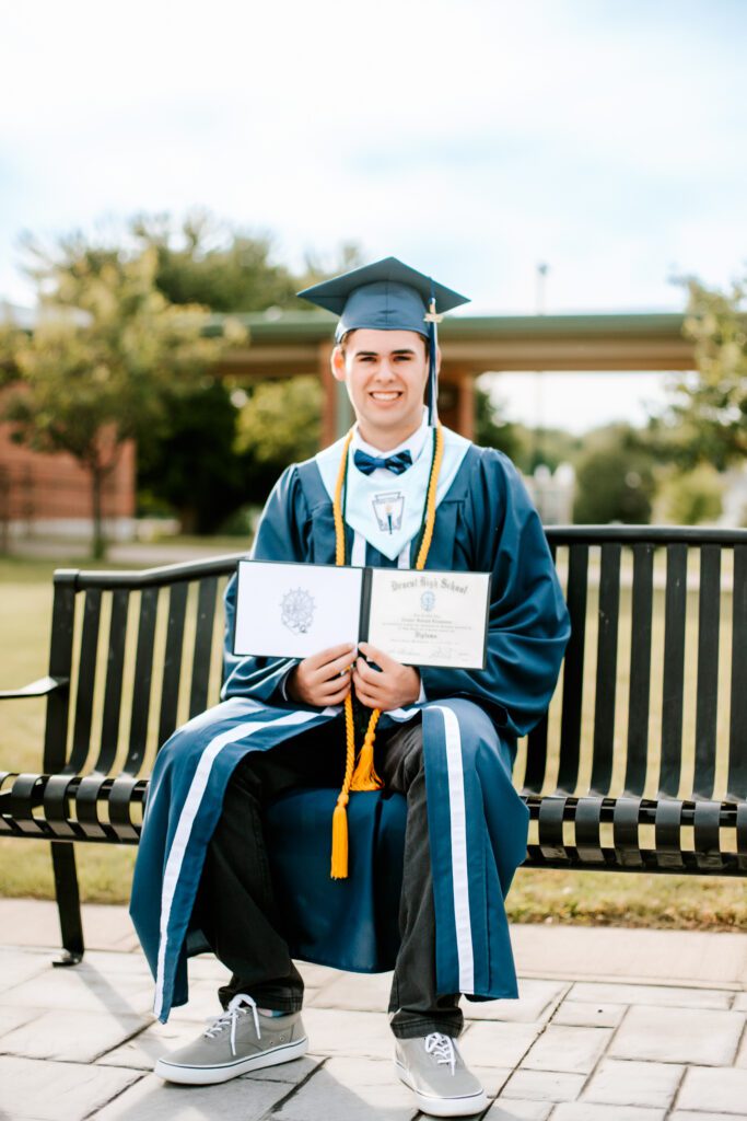 High school graduate wearing his cap and gown and holding his diploma, Massachusetts