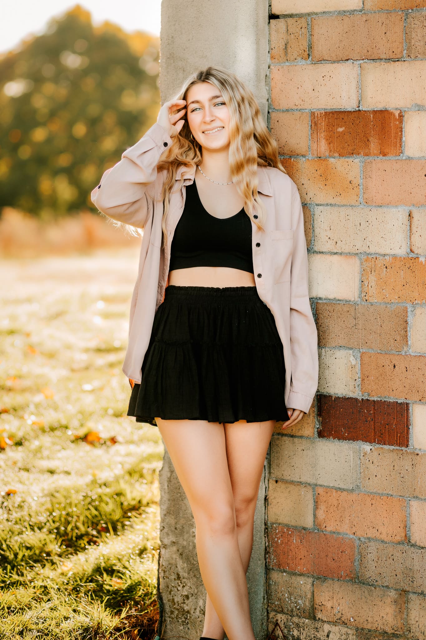 High school senior dressing in a cute black top and skirt set with an over shirt combines the best options for choosing what to wear for her senior photos.