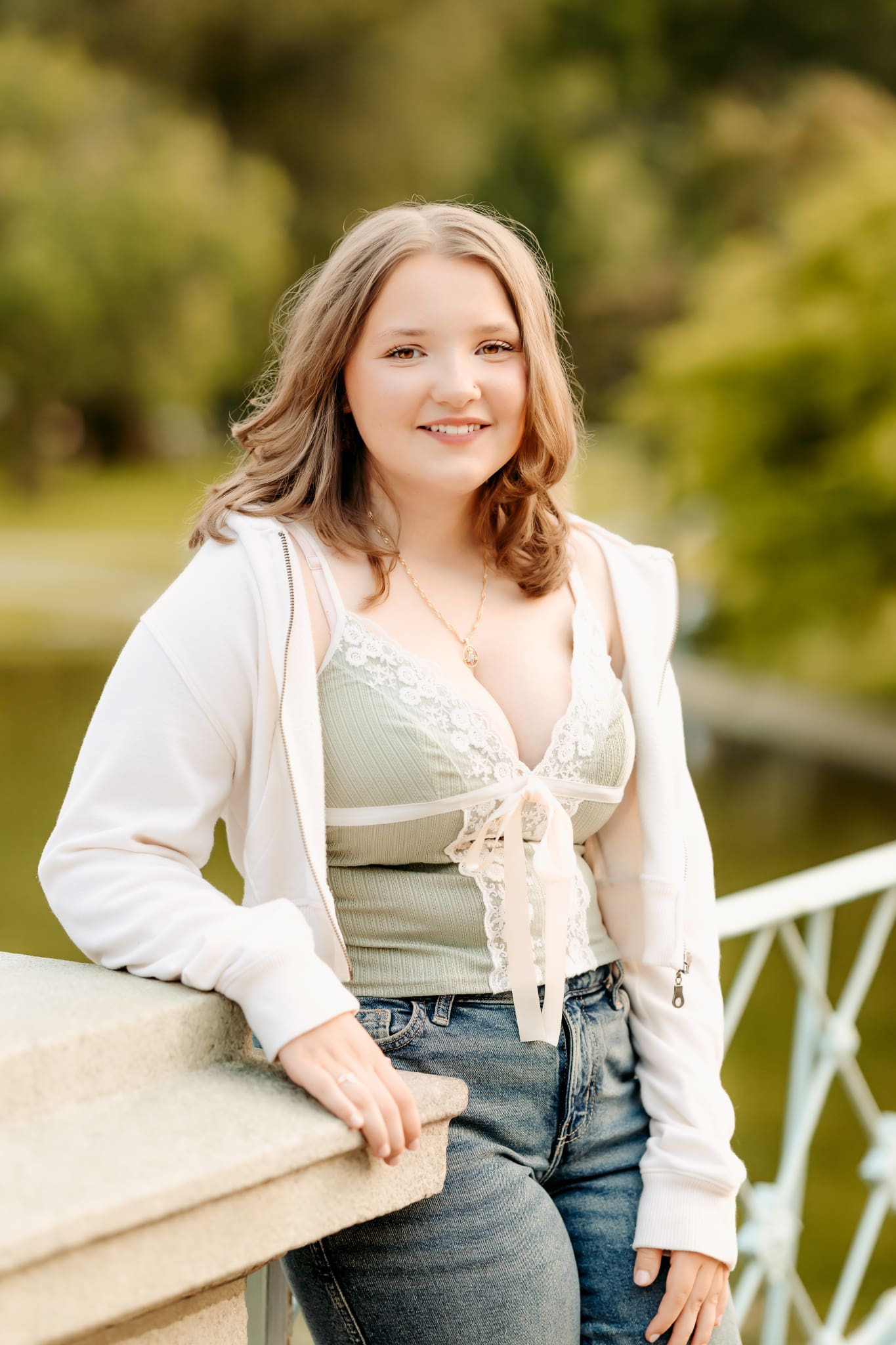 Senior girl standing along a bridge in her casual yet perfect clothes for her senior session.
