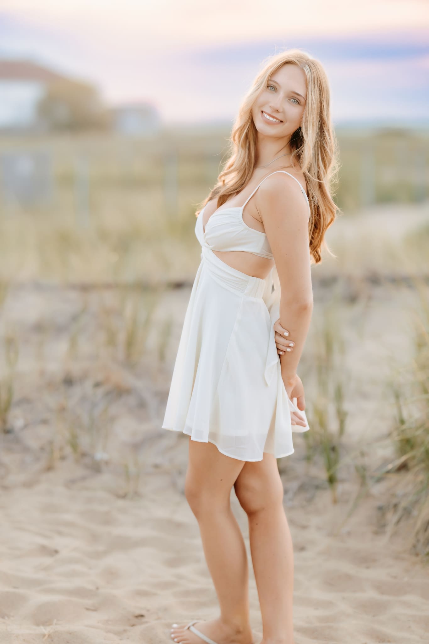 Senior girl standing in the dunes of the beach during her summer senior session in Massachusetts.