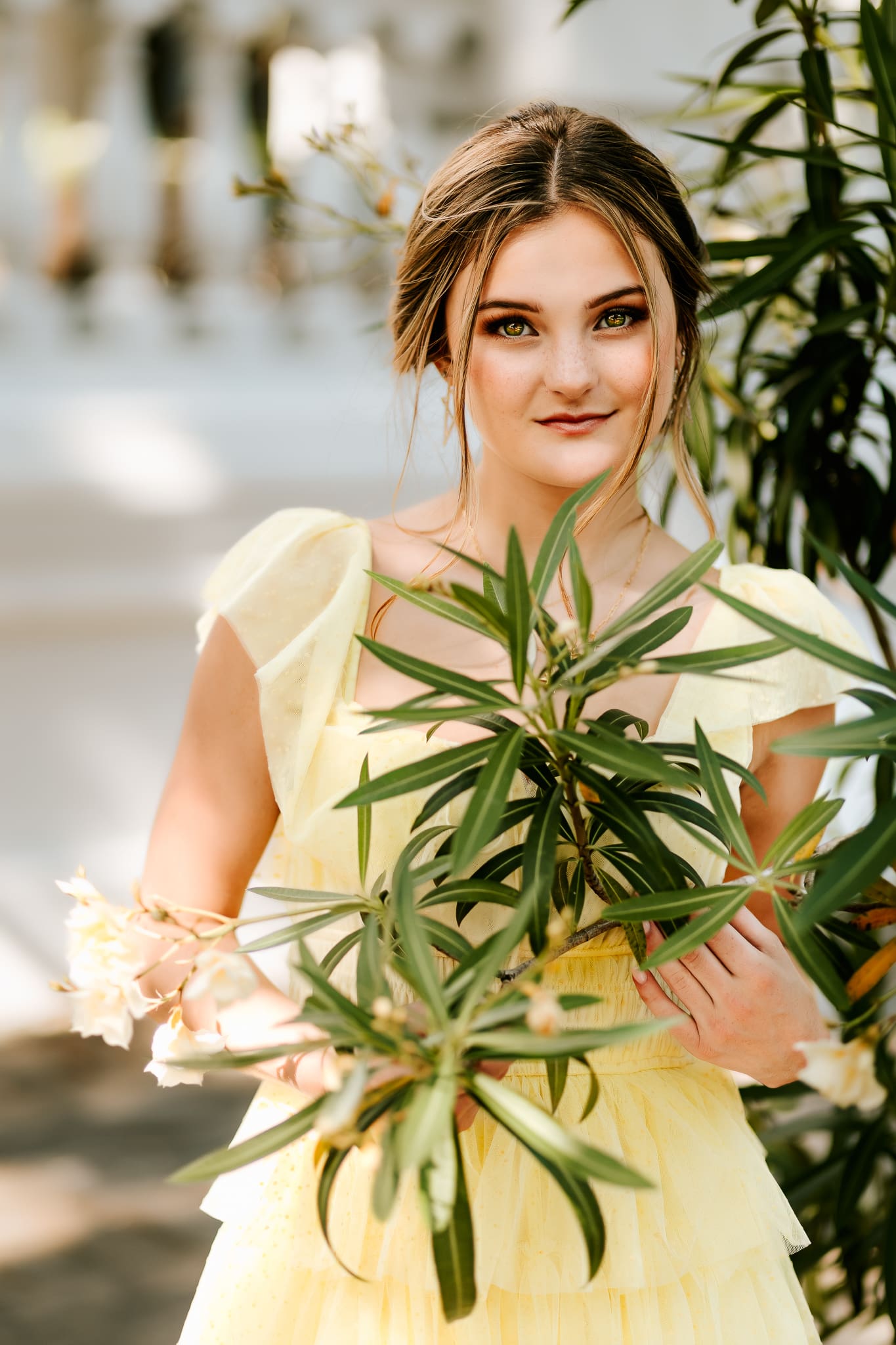 Senior girl framed by the leaves of a tree in this spring season photo session.