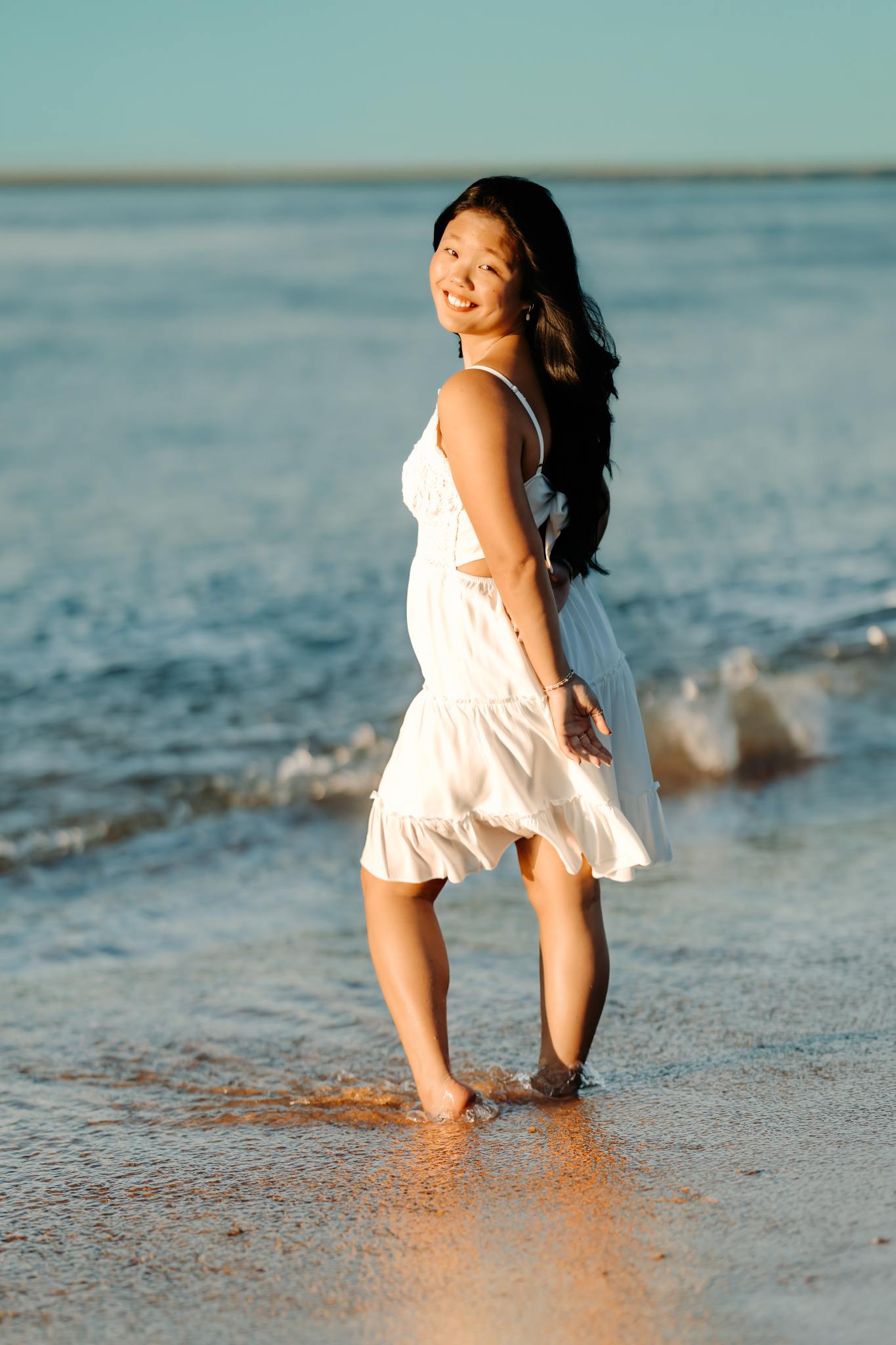 High school senior girl standing in the waves at Plum Island Beach, Newburyport, MA.