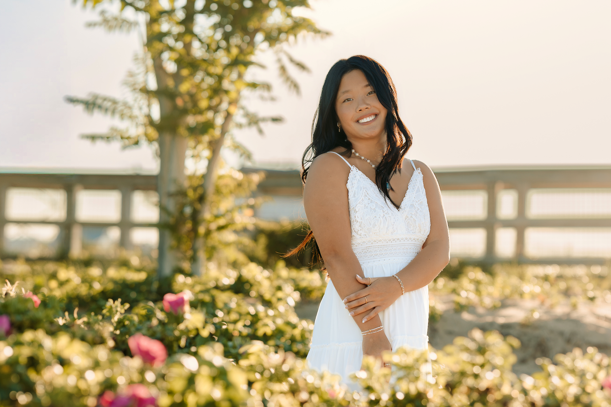 High school senior girl standing among the beach flowers in Plum Island beach.