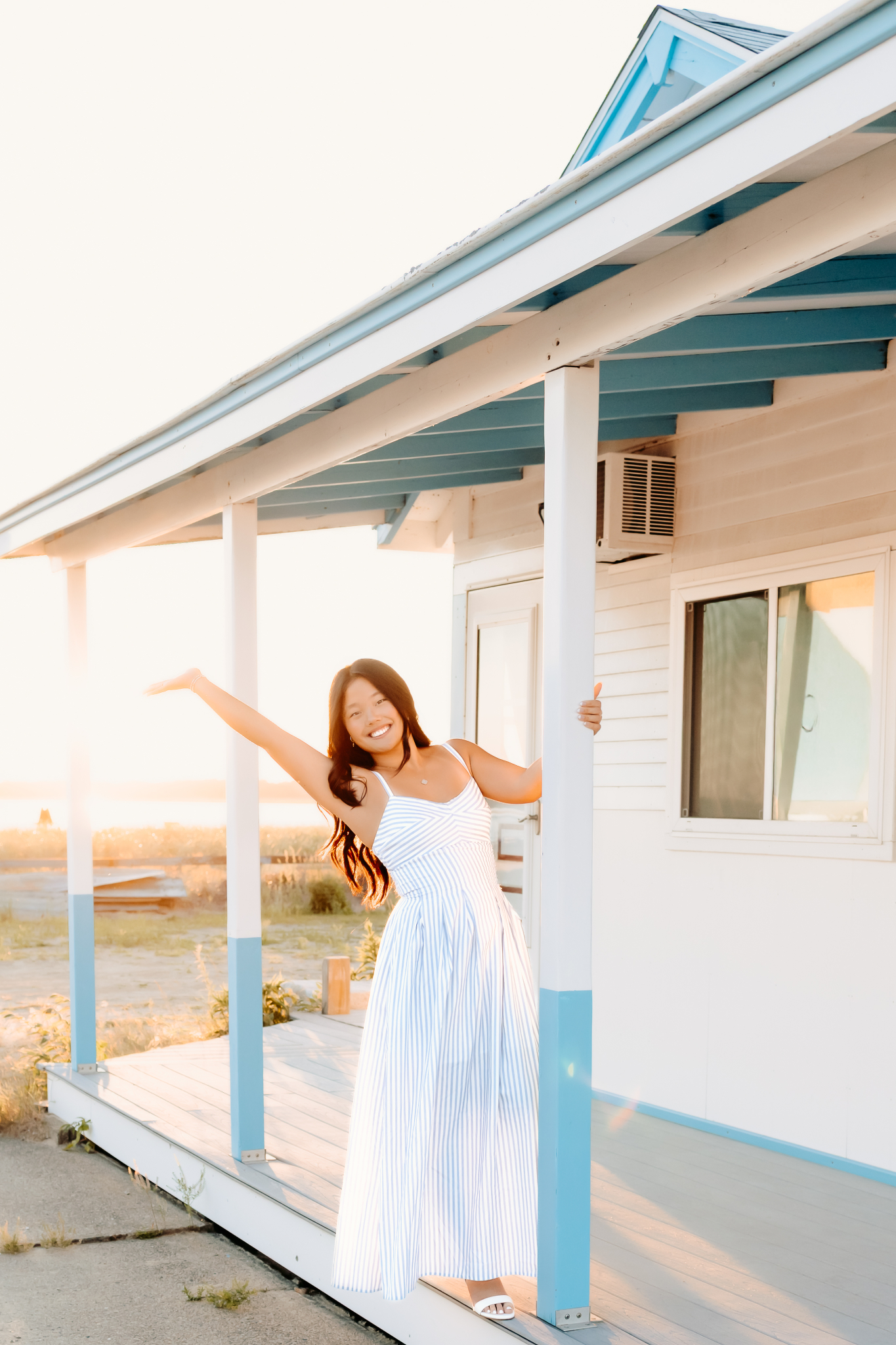 Senior girl having a fun "singing in the rain" moment during her senior photos in Newburyport, MA
