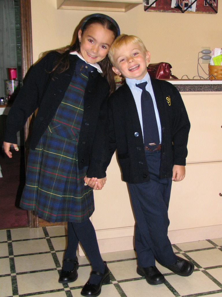 Brother and sister posing together for a first-day-of-school photo in elementary school