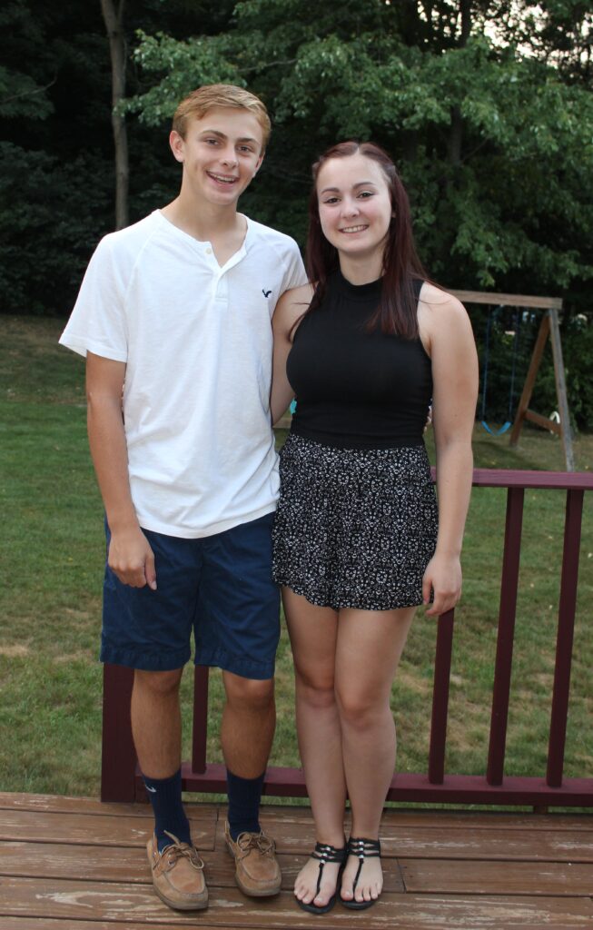 Brother and sister posing together for a first-day-of-school photo during high school