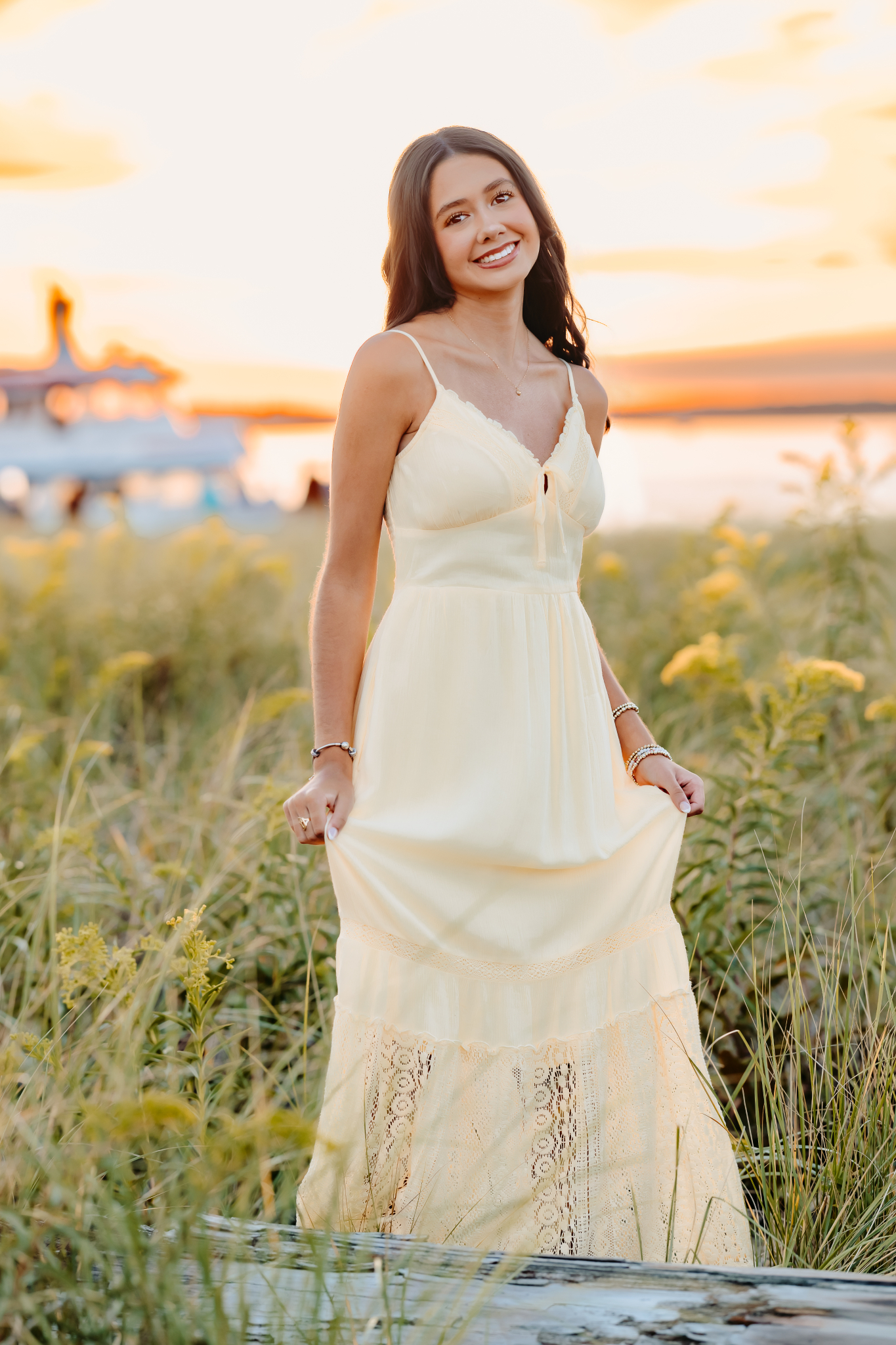 Class of 2027 senior sways in her yellow maxi dress during her senior photos in Massachusetts.