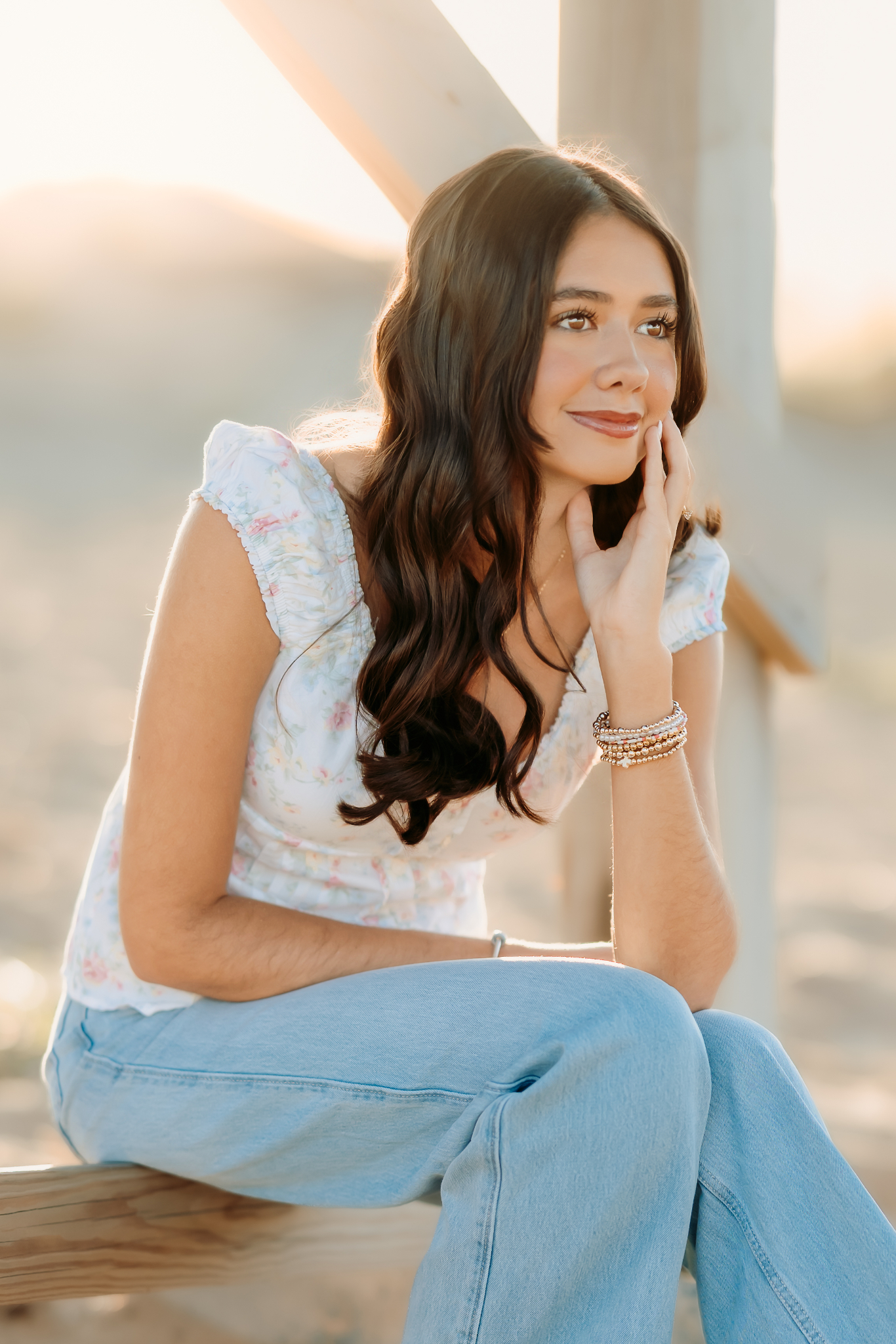 Senior girl sitting looking contemplative out toward the ocean at Plum Island, Newburyport, MA