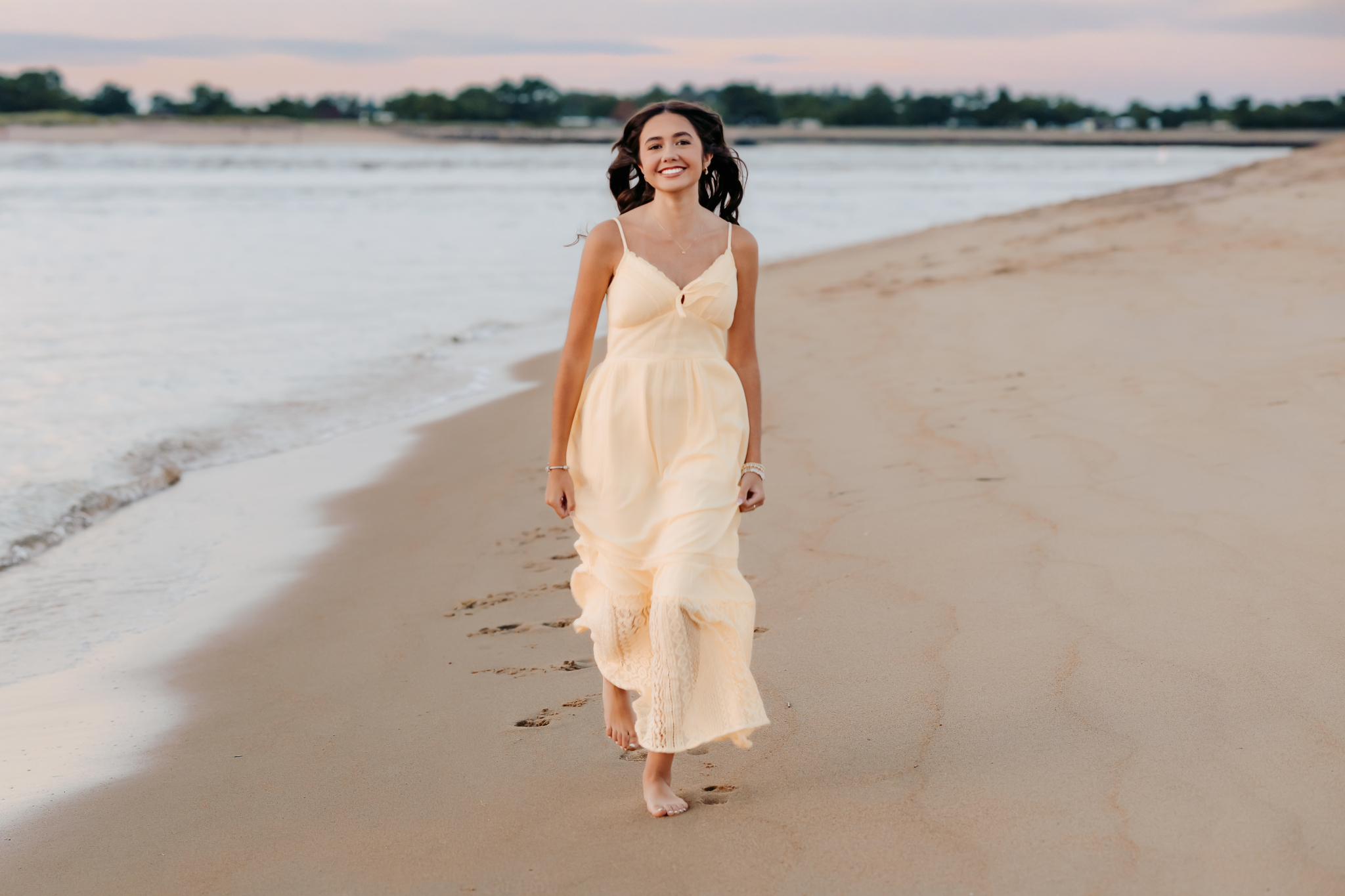 Senior girl running along the beach in a flowing yellow maxi dress in Newburyport, MA