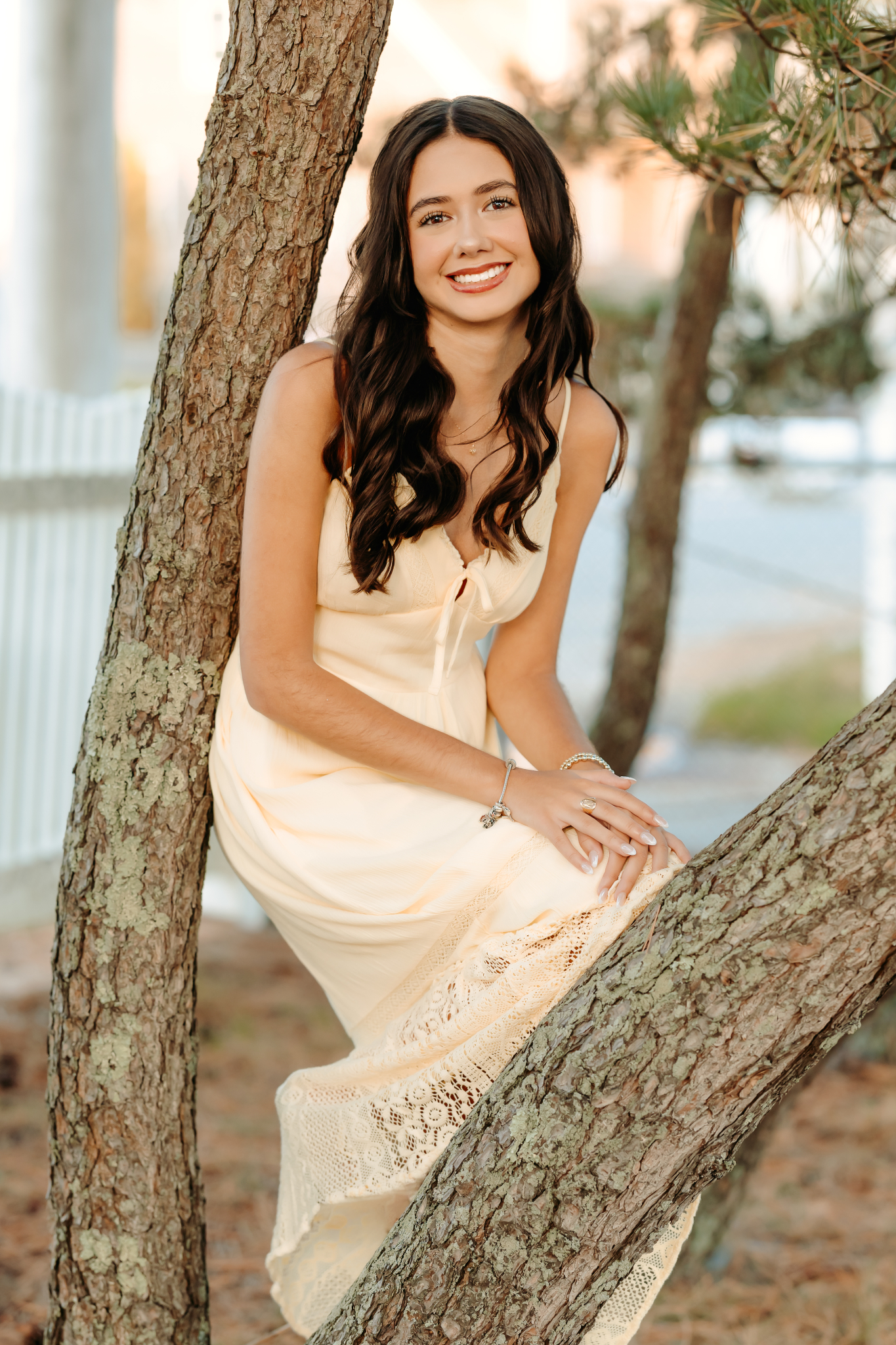 High school senior girl leaning against a tree during her senior photos.