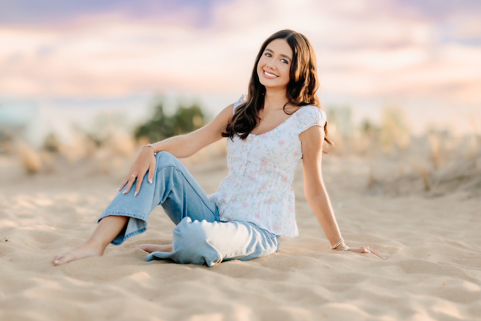 High school senior girl sitting on the beach in Newburyport for her senior photos